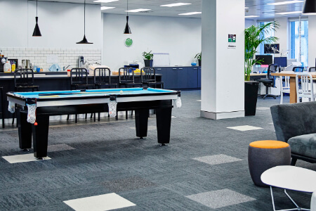 A pool table in an office breakout area.